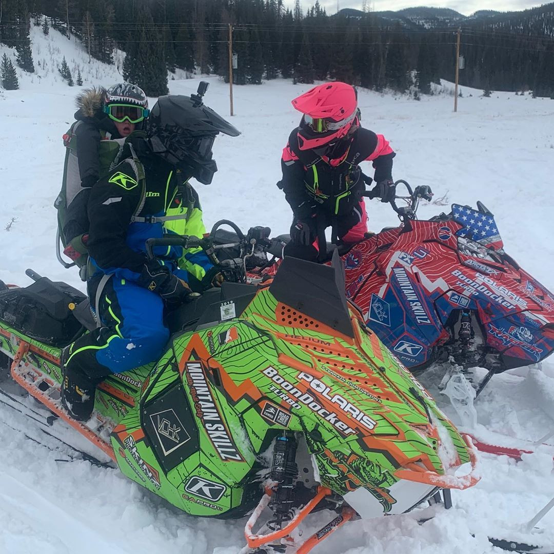  Cowboy rides his snowmobile with son Danger on his back