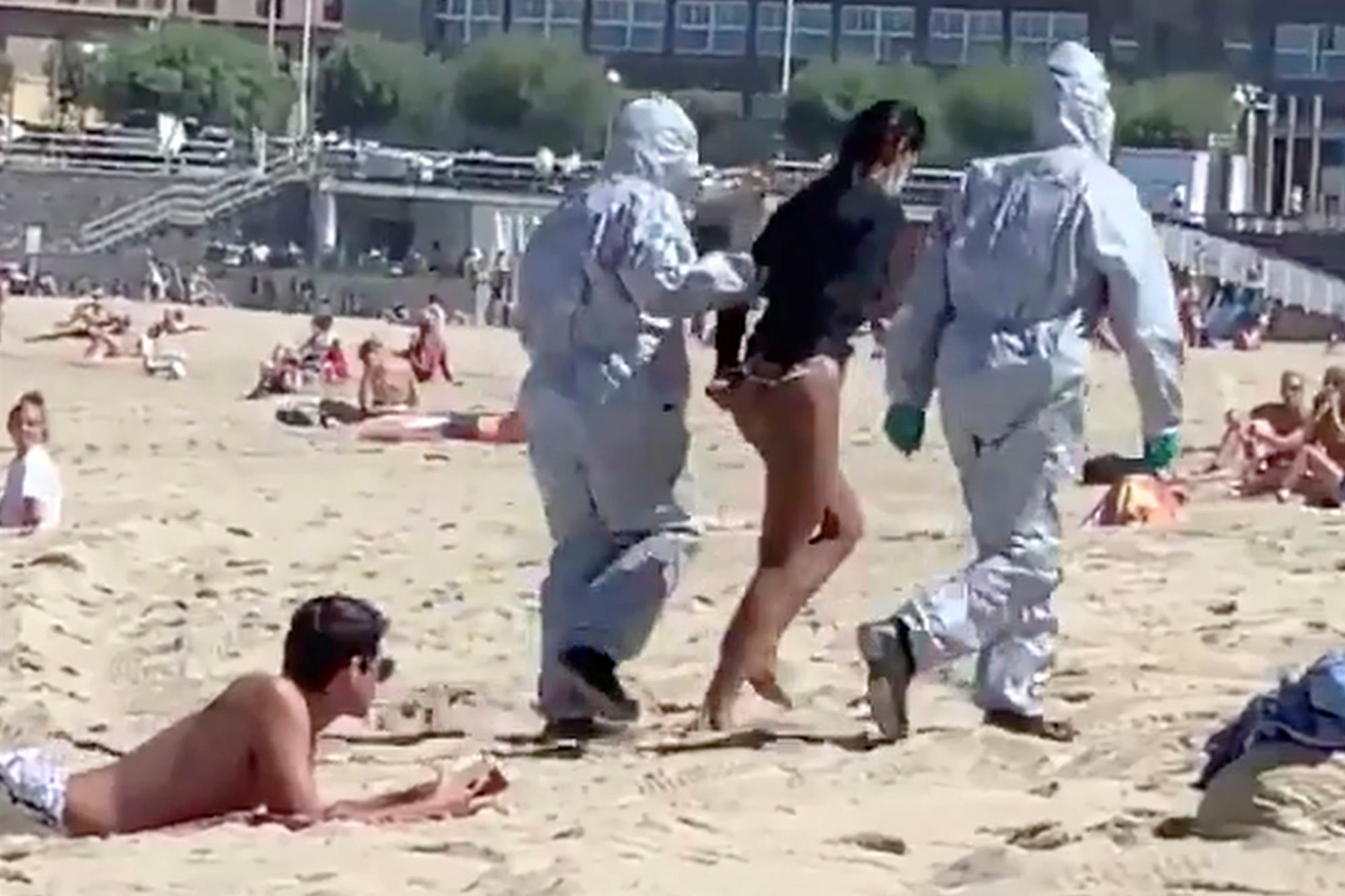 A woman was arrested on a Spanish beach after going surfing while she was suffering coronavirus.